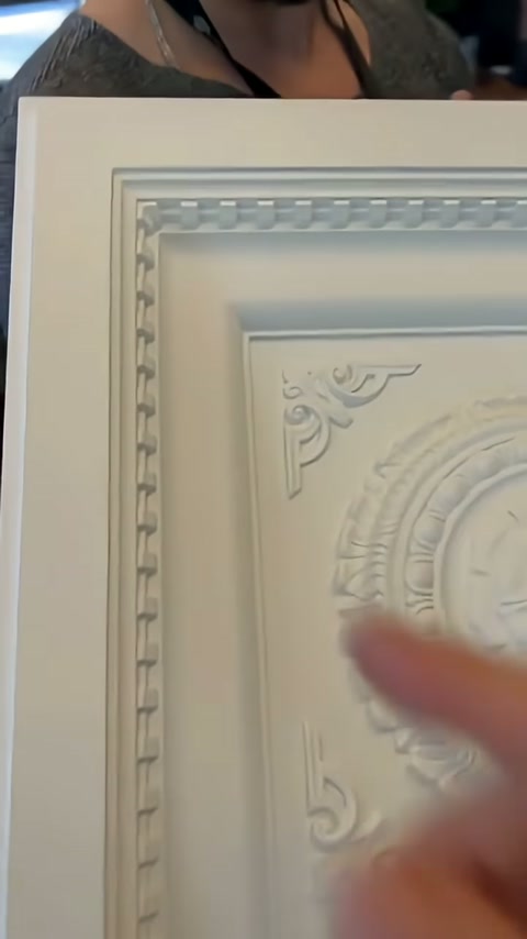 El hareketi, kaset panelin iç köşesindeki kabartma ayrıntıları vurguluyor.