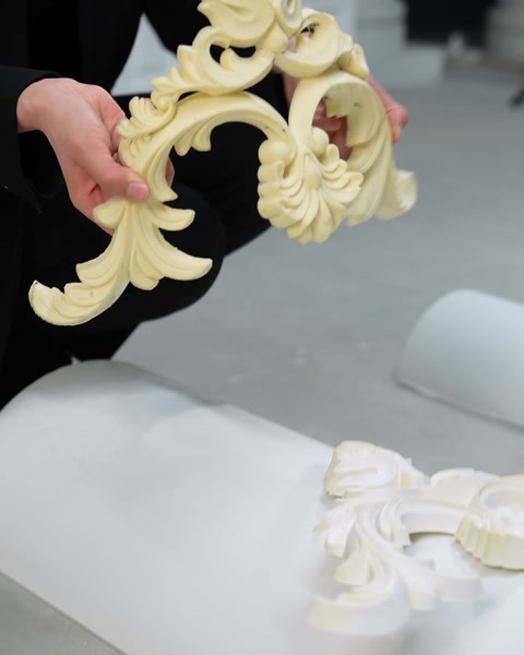 Elde tutulan kabartmalı süsleme parçası yakın çekimde inceleniyor