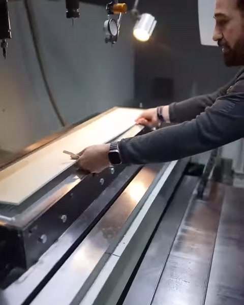 İşlenen uzun kalıp parçası operatör tarafından elle kontrol ediliyor