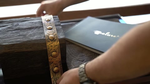 Eller, kabartmalı bandı ahşap dokulu kiriş üzerinde hizalıyor.