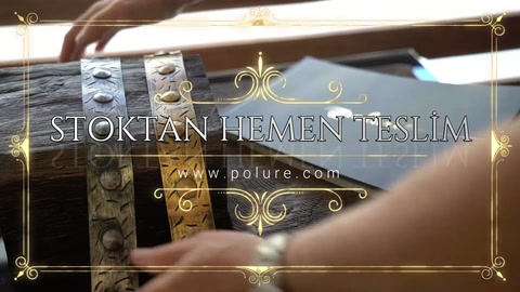 Kabartmalı metal aksesuar, ahşap dokulu kirişe aletle uygulanıyor.