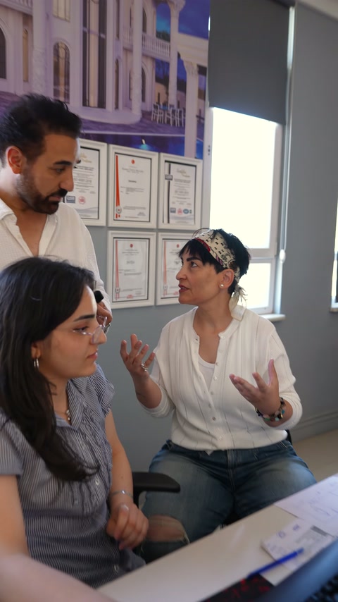 Tasarımcı iki ekip üyesine iç mekan yaklaşımını aktarıyor.