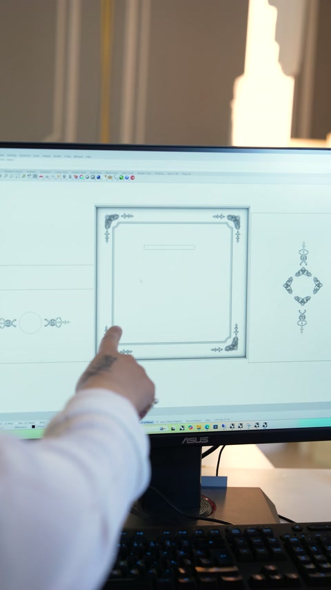 Monitördeki dekoratif çerçeve taslağı parmakla gösterilerek değerlendiriliyor.