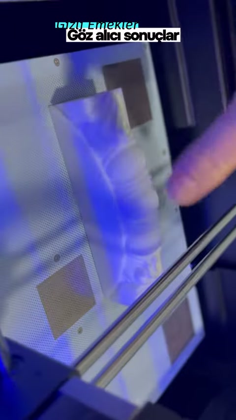 El, mavi ışıklı kabin içinde küçük parçayı konumlandırıyor