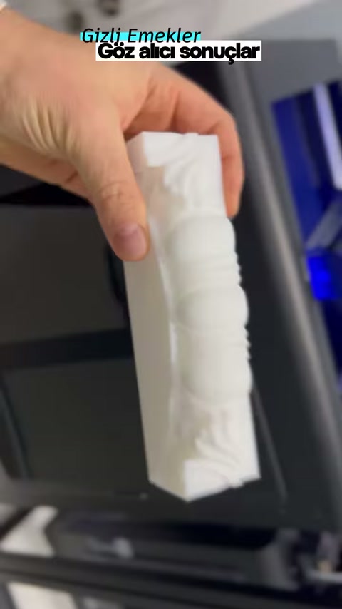 Uzun dekoratif numunenin oluklu ve kıvrımlı yüzeyi elde gösteriliyor