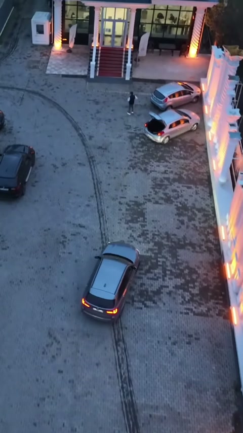 Merdivenli iş yeri girişi, dekoratif duvar ve park alanıyla birlikte görülüyor