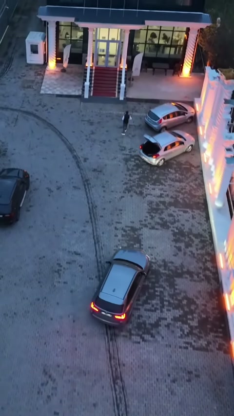 Işıklı cephe sütunları, kırmızı merdivenli bina girişini iki yandan çerçeveliyor