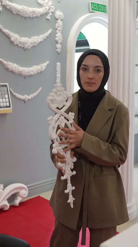 Sunucu uzun süsleme modelini gövdesinin önünde sabit tutuyor