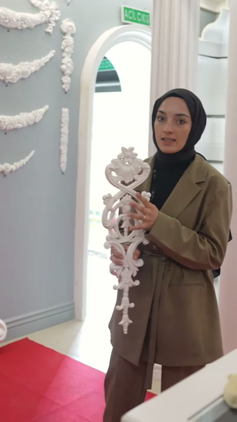 Uzun beyaz bezemenin üst kıvrımları elde desteklenerek tanıtılıyor