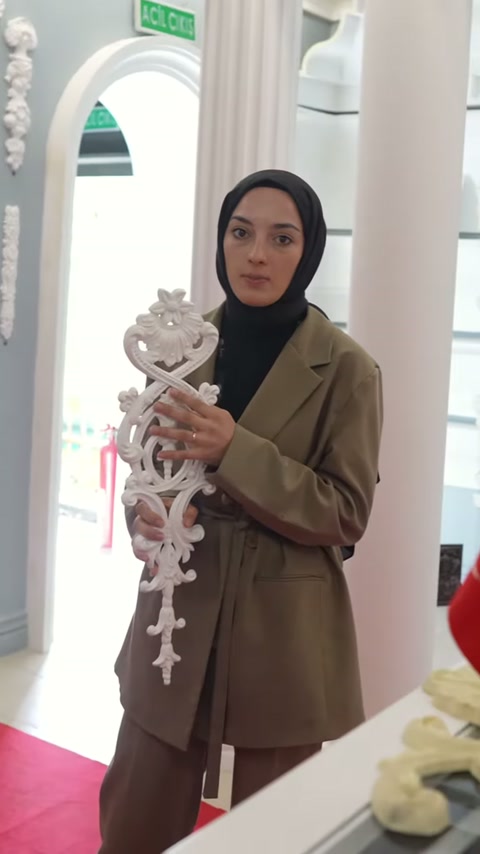 Sunucu klasik motif parçasını iki eliyle dengeli biçimde tutuyor