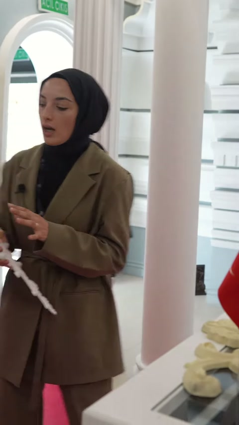 Sunucu ince ve uzun motif parçasını masa üzerinde inceliyor