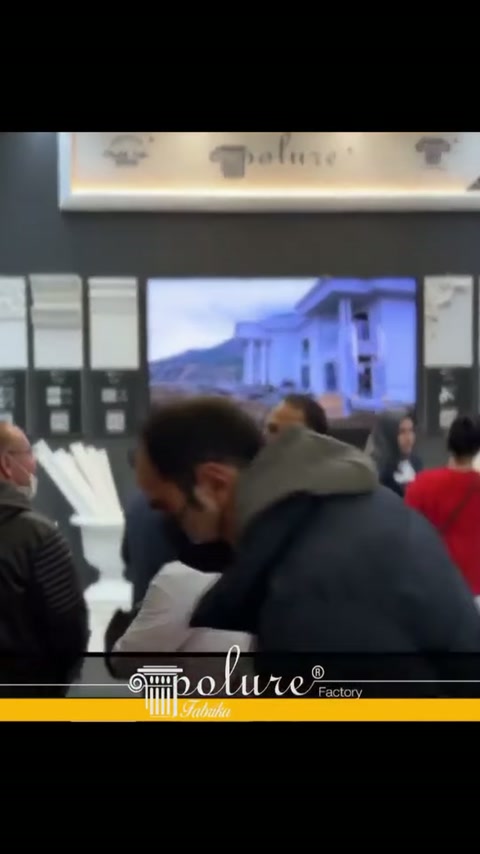 Ekran altındaki profilli duvar panolarını ziyaretçiler yakından inceliyor