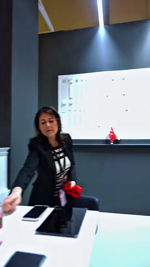 Görevli, dekoratif ürün panosu önündeki stant masasında hazırlık yapıyor