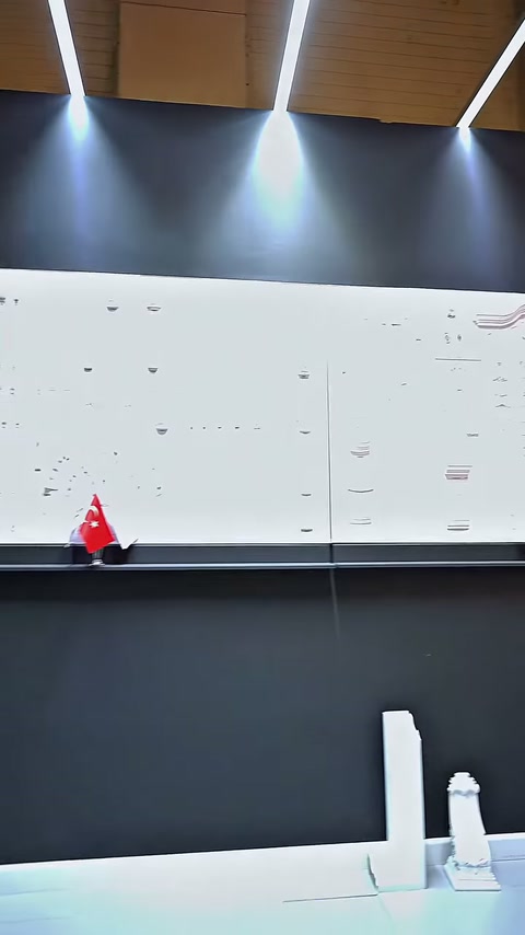 Stant duvarındaki düzenli profil numuneleri, masa arkasından görüntüleniyor