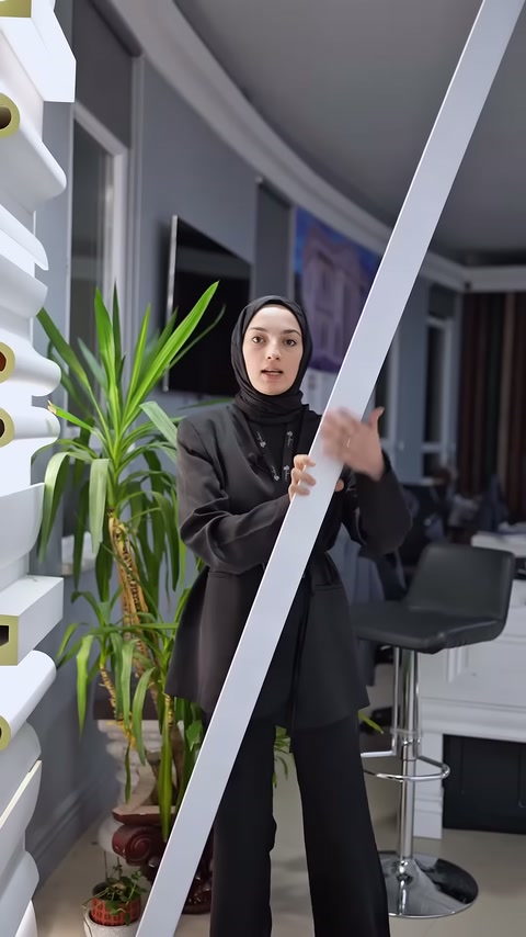 Sunucu uzun ve düz beyaz poliüretan profili dikey konumda tutuyor.