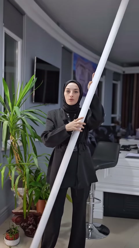 Sunucu beyaz profil parçasını iki eliyle dik konumda sergiliyor.