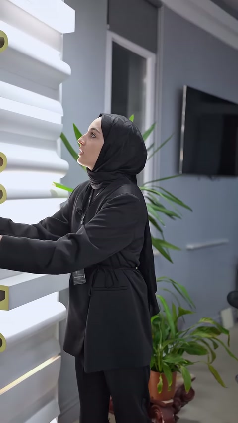 Dikey kartonpiyer parçası, farklı kesitlerin bulunduğu standın yanında tutuluyor.