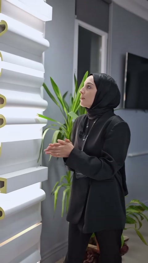 Sunucu ürünü bıraktıktan sonra kartonpiyer standı önünde anlatım yapıyor.