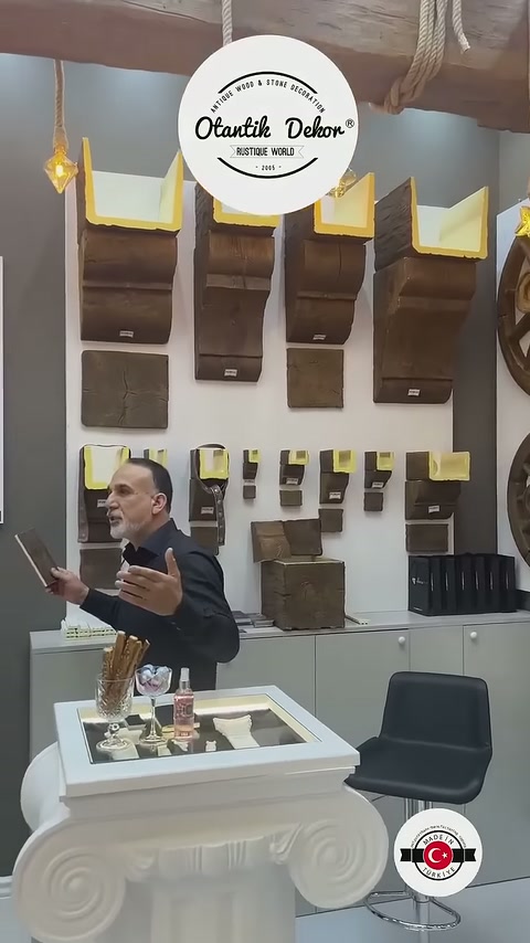 Görevli ahşap desenli kiriş parçalarının önünde ziyaretçilere bilgi veriyor