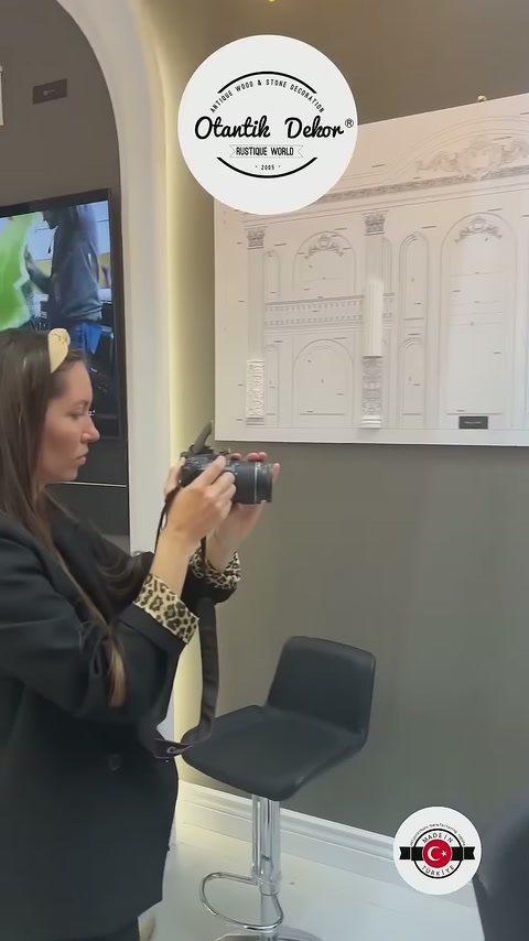 Kameralı ziyaretçi dekoratif profil çizimlerinin bulunduğu panoyu inceliyor