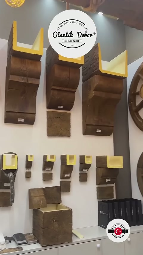 Çeşitli koyu tonlardaki kiriş ve kaplama parçaları stantta sıralanıyor
