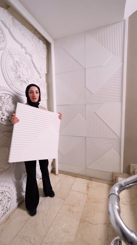 Kare paneldeki çapraz oluklar, uygulama yapılmış duvar önünde inceleniyor