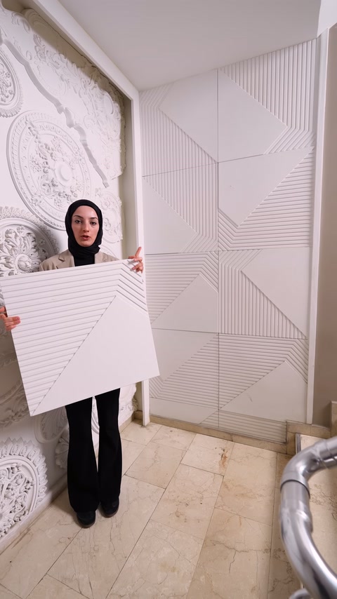 Sunucu, üçgen bölümlü panelin kabartmalı desenini kameraya doğru tutuyor