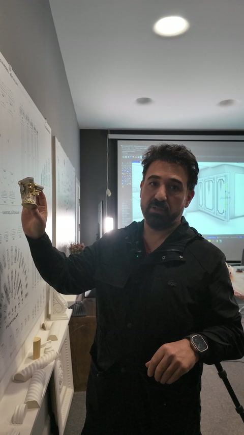 Süslü sütun başlığı örneği, sunucunun elinde yakından sergileniyor.