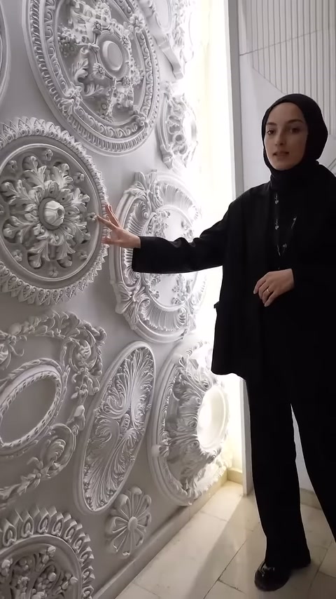 Sunucu, kabarık çiçek merkezli tavan dekorunun yüzeyini işaret ediyor