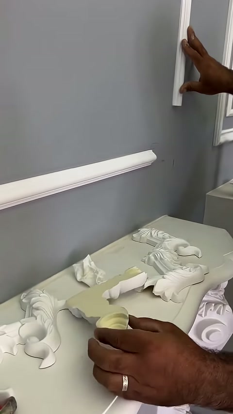 Gri duvardaki boş çıta birleşimi ve çalışma sehpası görülüyor