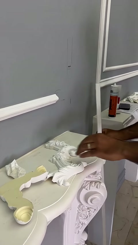Usta sehpadaki farklı beyaz dekoratif elemanlara doğru uzanıyor
