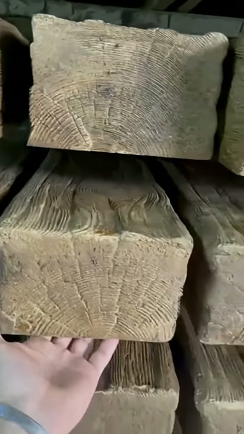 Bir el, raftaki kalın merteği altından destekleyerek inceliyor.