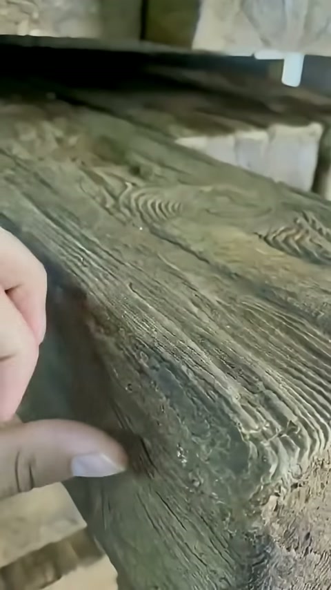 Parmaklar, uzunlamasına damar desenli mertek yüzeyini yakından yokluyor.