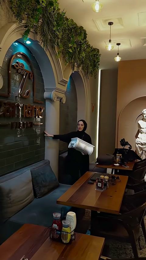 Yeşilliklerle çevrelenen dekoratif kemer ve sütun detayları restoranı süslüyor