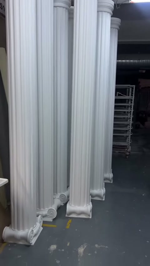 Uzun beyaz sütunların gövde yivleri tavana doğru uzanıyor