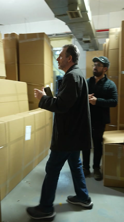 Müşteriler paketlenmiş dekorasyon ürünlerini depoda incelemeye hazırlanıyor.
