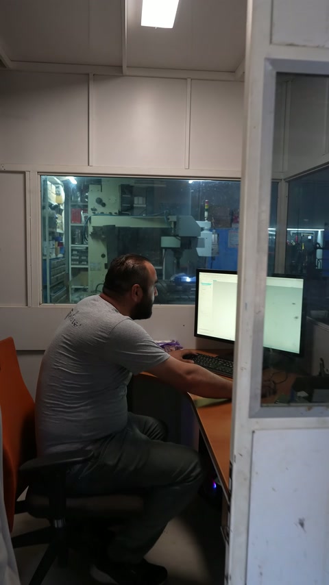 Çalışan, makine başında üretim ekipmanını kontrol eden operatörle konuşuyor