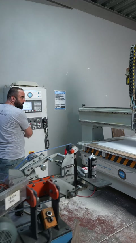 Büyük CNC tezgâhının yanında operatör ve işleme alanı görülüyor