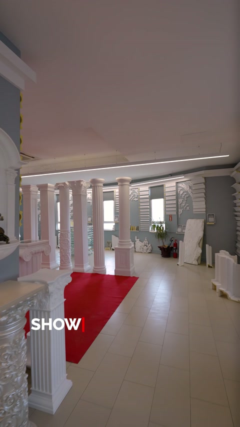 Showroom boyunca sıralanan dekoratif sütunlar ürün geçişi oluşturuyor