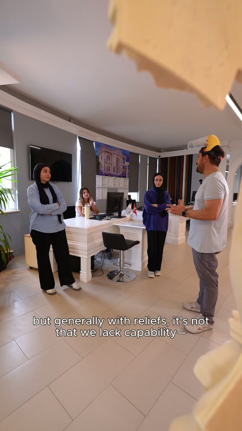 Yetkili, masa çevresindeki ekibe özel ölçekte tasarım örneğini anlatıyor.