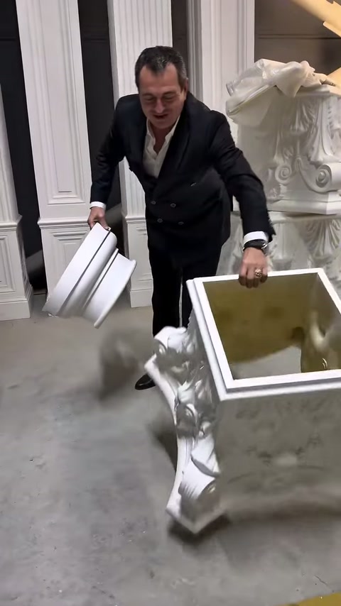 Müşteri, büyük oyma bezemeli parçayı showroom zeminine dikkatle indiriyor
