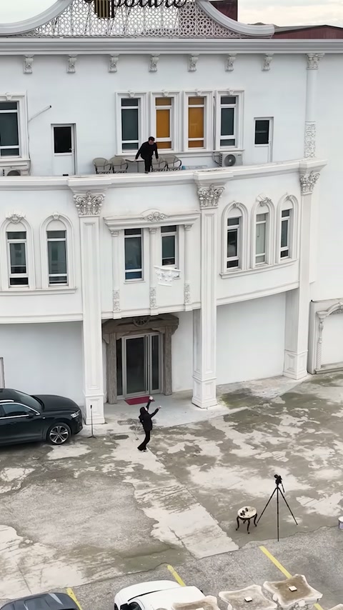 Beyaz klasik cephede dekoratif sütunlar ve pencere süslemeleri görülüyor