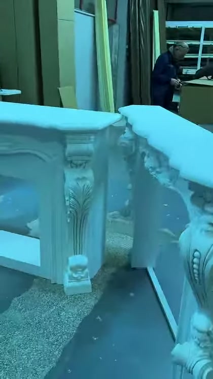 Beyaz şömine çerçevesinin yaprak desenli dikey ayağı öne çıkıyor