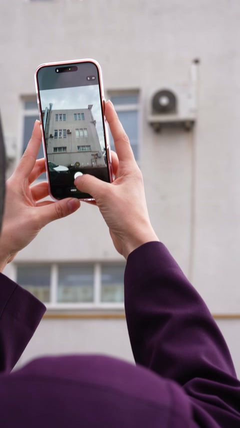 Telefon ekranında binanın sade pencereleri ve dış cephesi görüntüleniyor