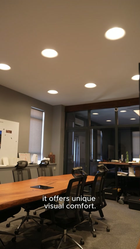 Uzun toplantı masasının üzerindeki amorf aydınlatmalar tavana yayılıyor