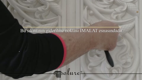 Dekoratif poliüretan panelin boyalı kabartmaları yakın planda kontrol ediliyor