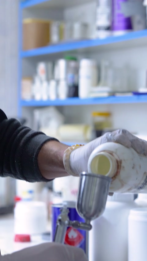 Eldivenli görevli sıvı karışımı püskürtme tabancasının haznesine aktarıyor