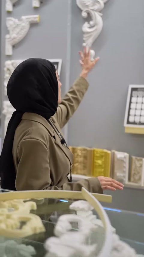 Sunucu büyük yaprak motifli köşe süslemesini eliyle gösteriyor.