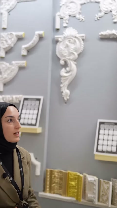 Sunucu küçük geometrik köşe numunelerini işaret ederek konuşuyor.