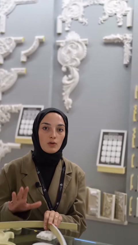 Showroom duvarındaki çiçekli köşe süsleri sunumun arka planını oluşturuyor.